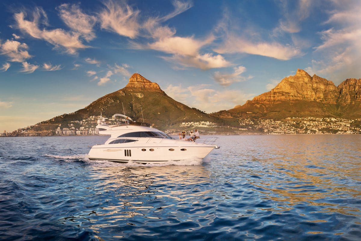 Yacht in Camps Bay, with a view of Twelve Apostles - South African Tourism